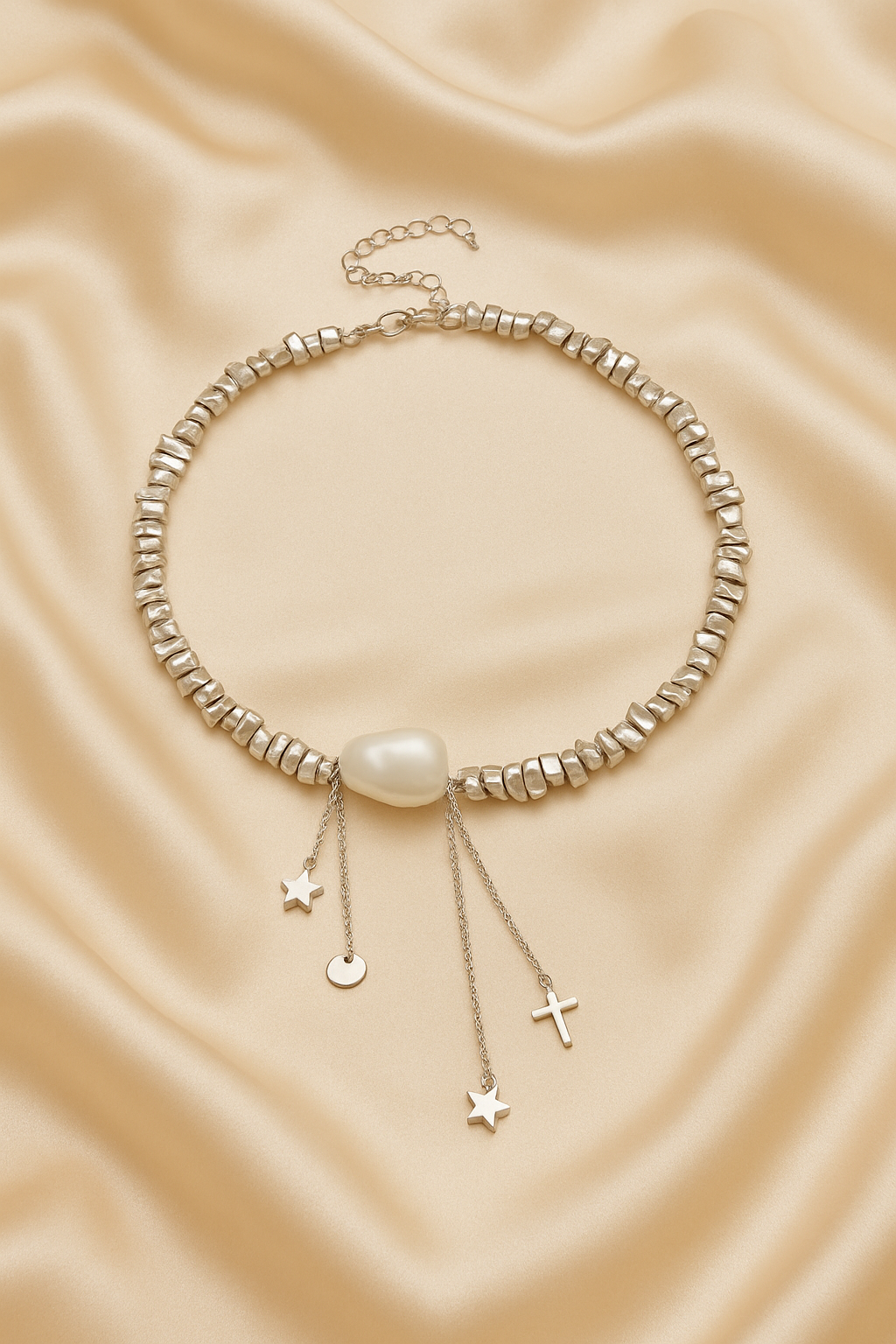 Necklace with pearls and small hanging charms on a beige fabric background