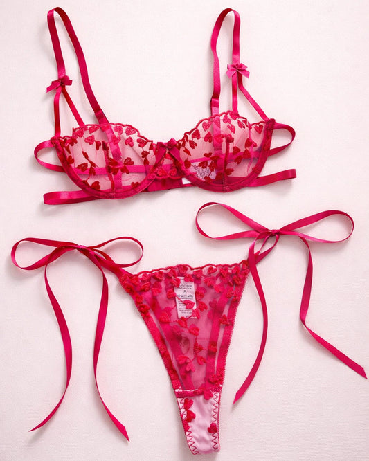 Pink lingerie set with floral details on a light pink background