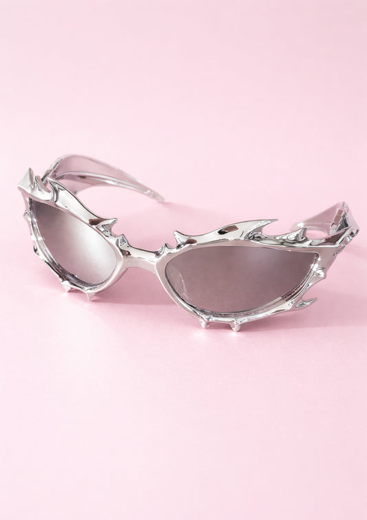 Silver sunglasses with a unique design on a pink background