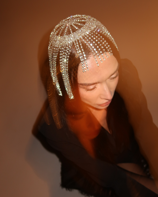 Woman wearing a decorative headpiece with a warm brown background