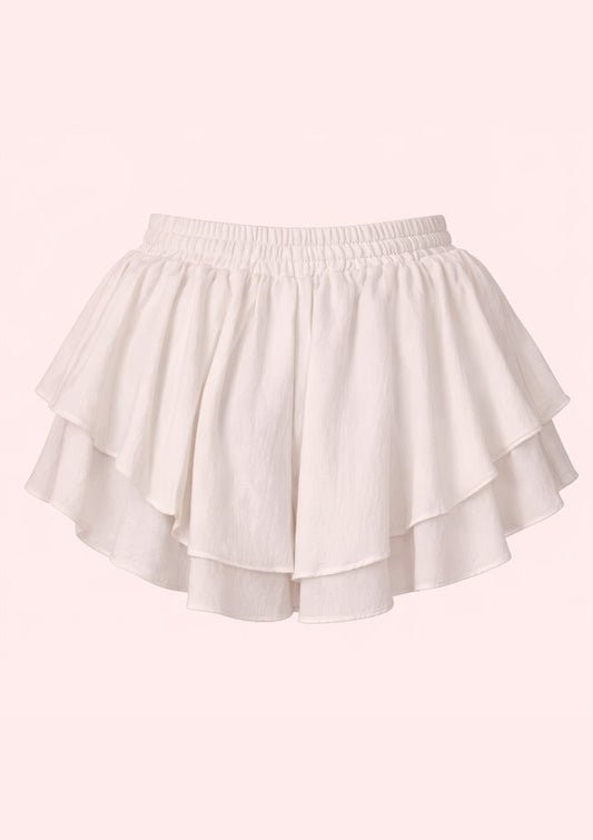 White shorts with ruffled layers on a light pink background