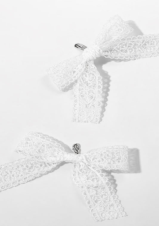 Two white lace bows shoe charms on a light gray background