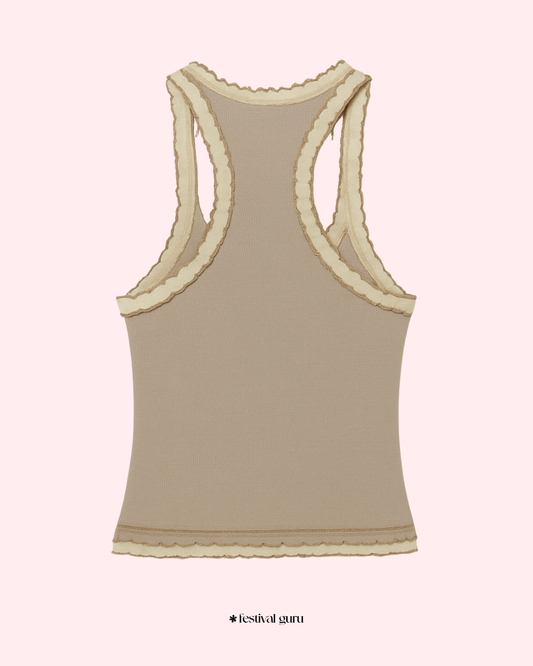 Beige tank top with lace trim on a light pink background