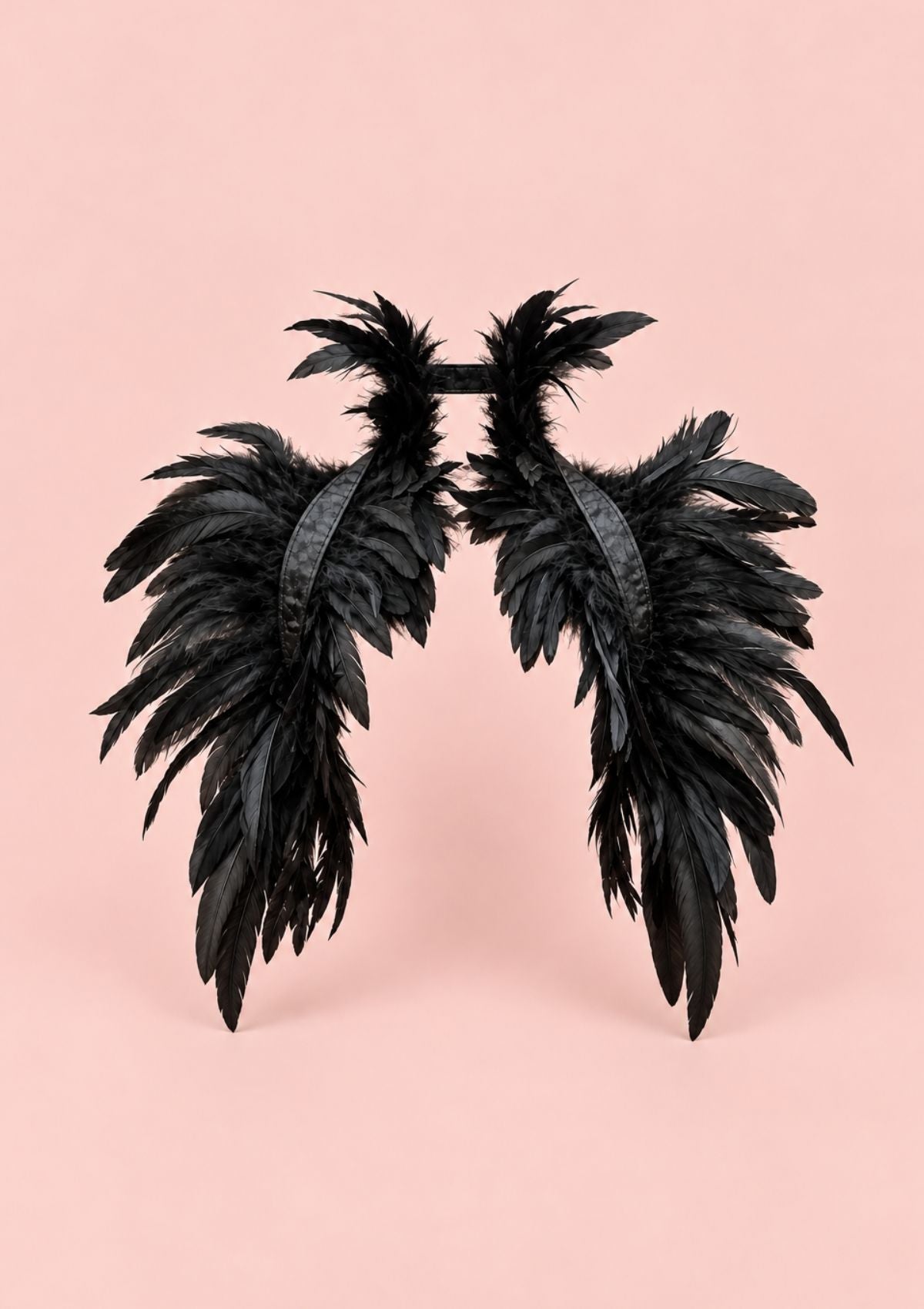Black feather wings accessory with a black headband, displayed against a solid light pink background.
