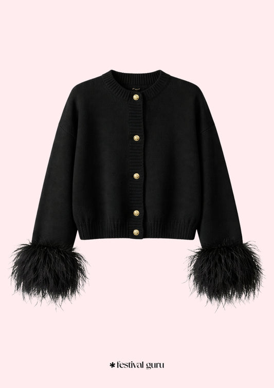 Black cardigan with feathered cuffs on a pink background