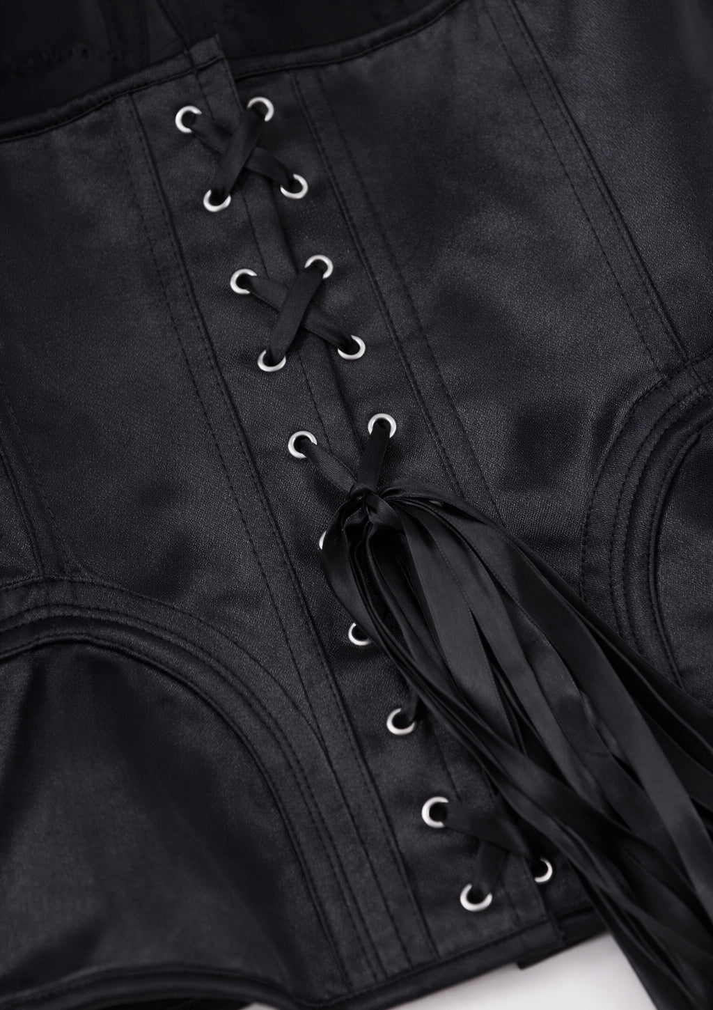 Close-up of a black corset with metal hooks on a white background
