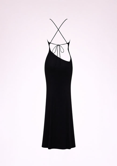 Black slip dress with thin straps on a light pink background