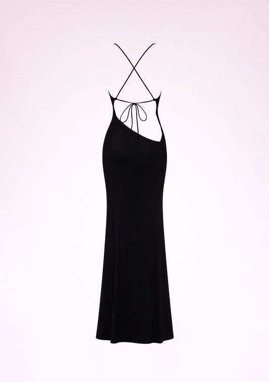Black slip dress with thin straps on a light pink background