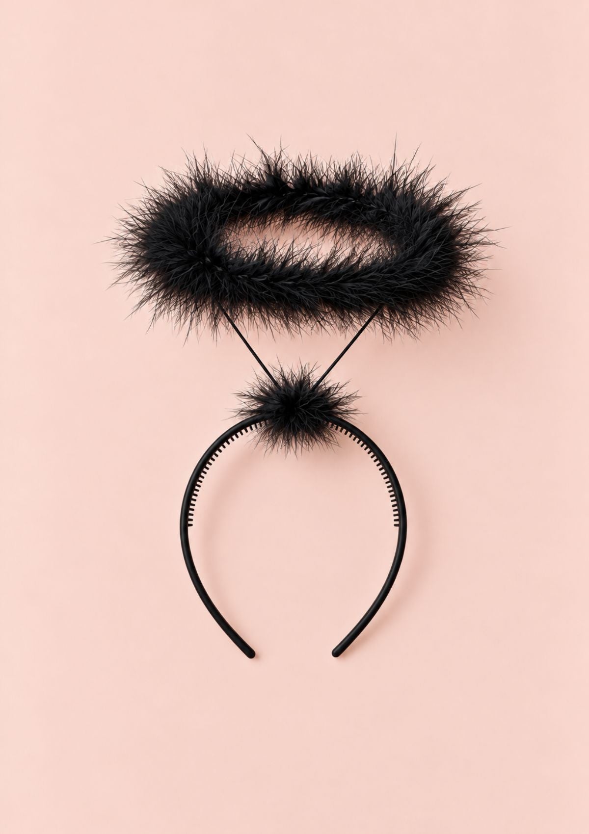 A black furry headband with a matching fuzzy pom-pom and thin black elastic cords, laid flat on a solid pale pink background.