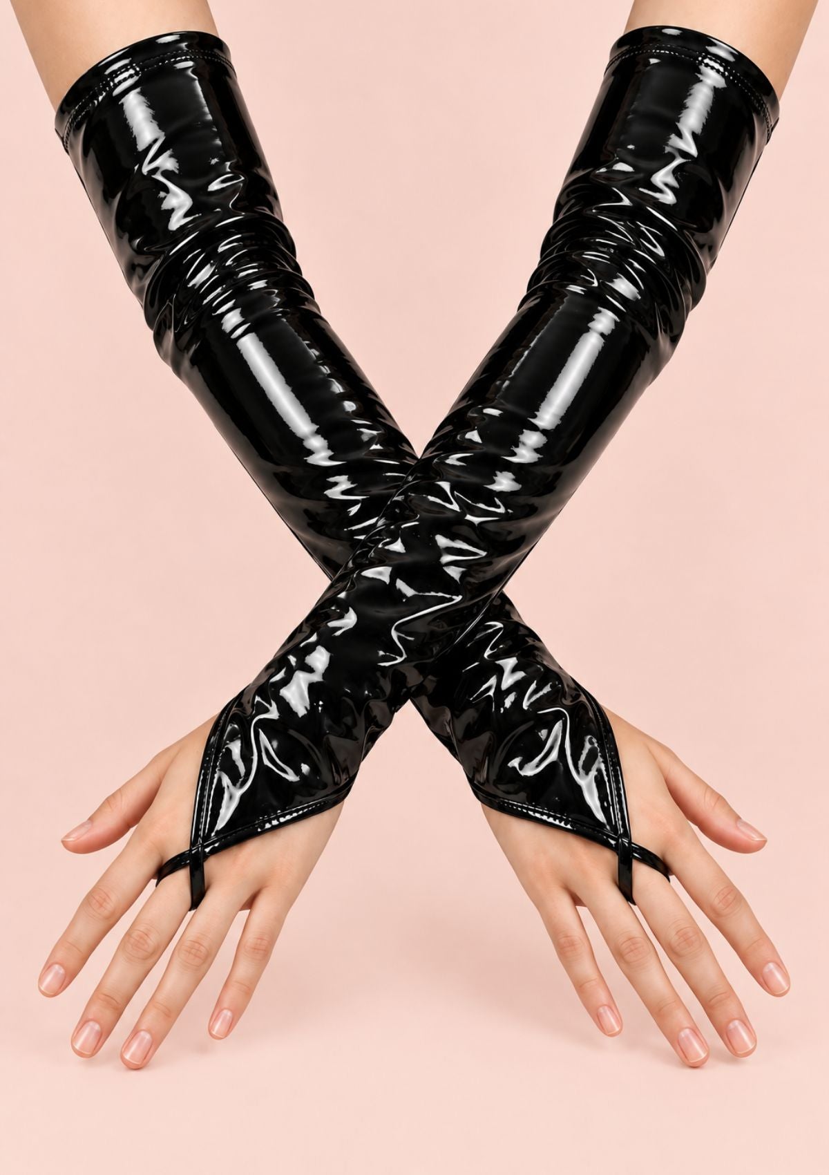 A pair of glossy black patent leather fingerless gloves worn on both arms, crossed over each other against a solid pale pink background.