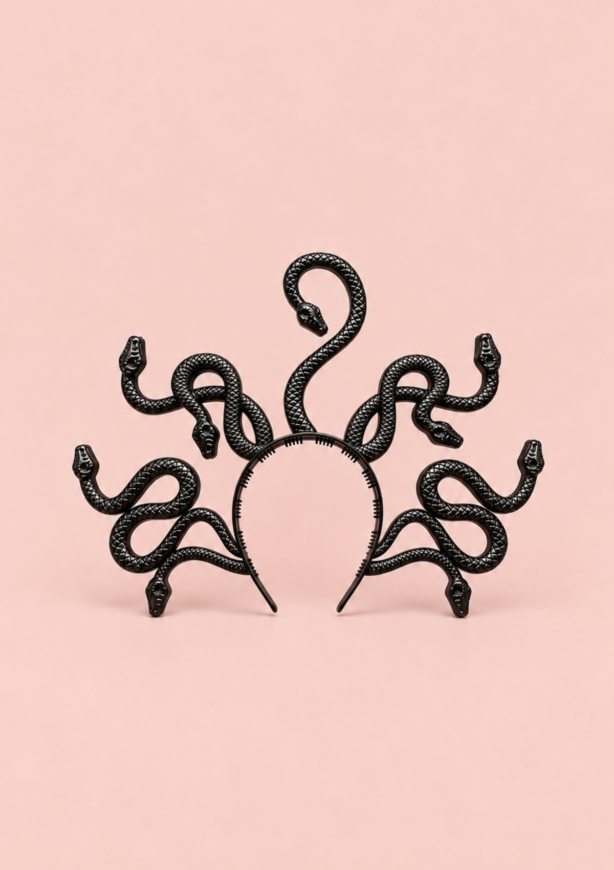 A black snake-themed headband featuring six coiled snakes with raised heads around a circular band, displayed against a solid pale pink background.