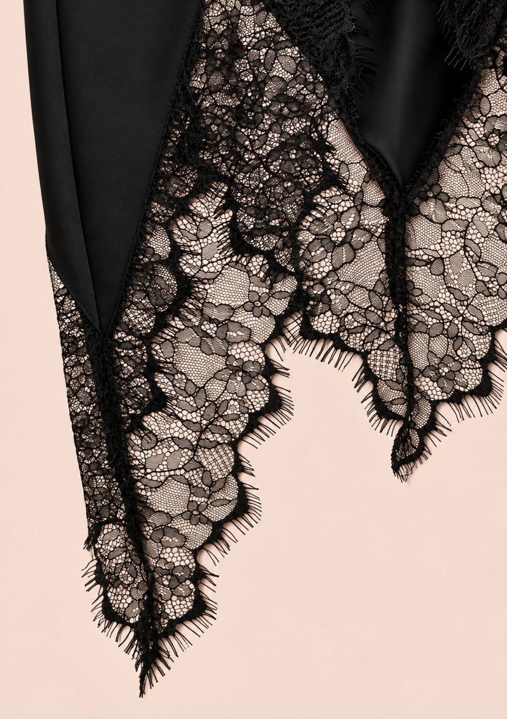 Black skirt detail with an uneven hem and lace panels at the bottom