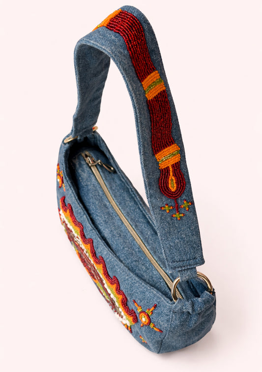 Blue denim bag with colorful embroidery on a white background