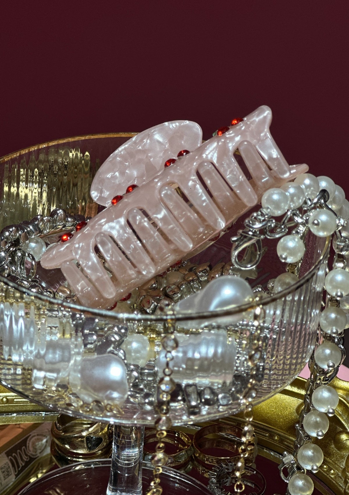 Pink hair clip with pearls on a decorative stand