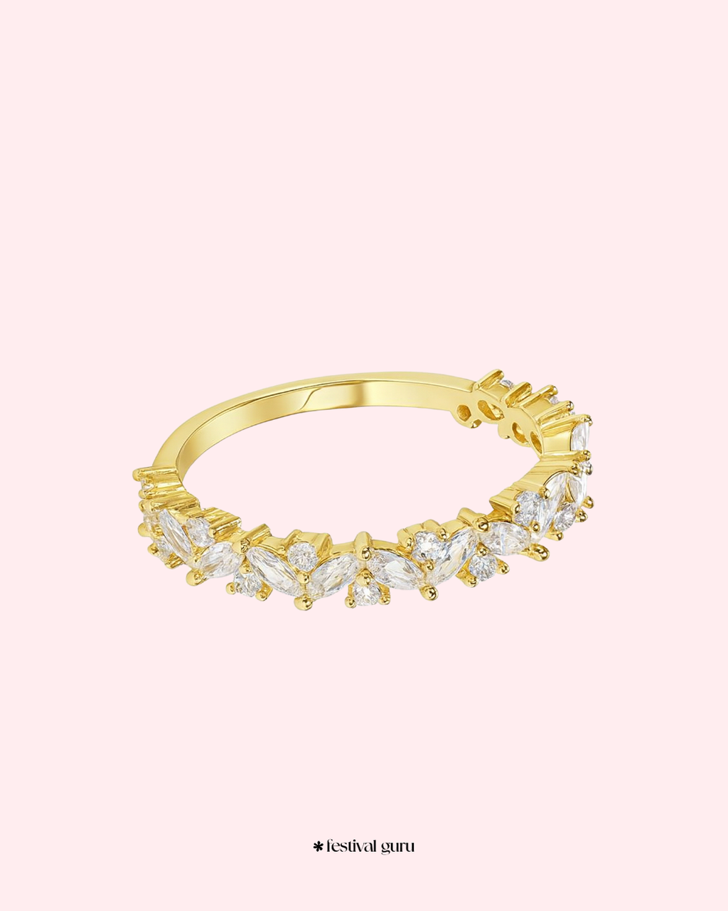 Gold ring with diamond-like stones on a light pink background