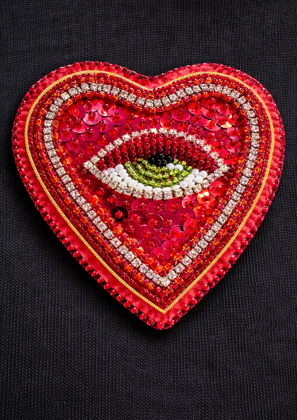Heart-shaped patch with eye design on a black background