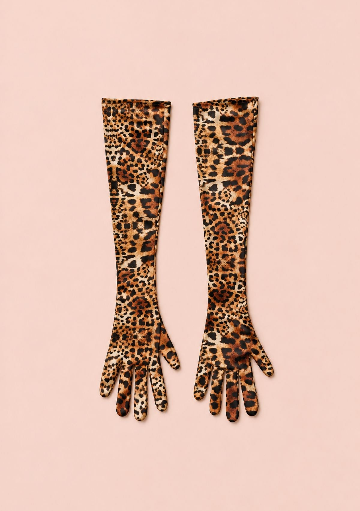 A pair of long leopard-print gloves laid flat on a solid pale pink background.