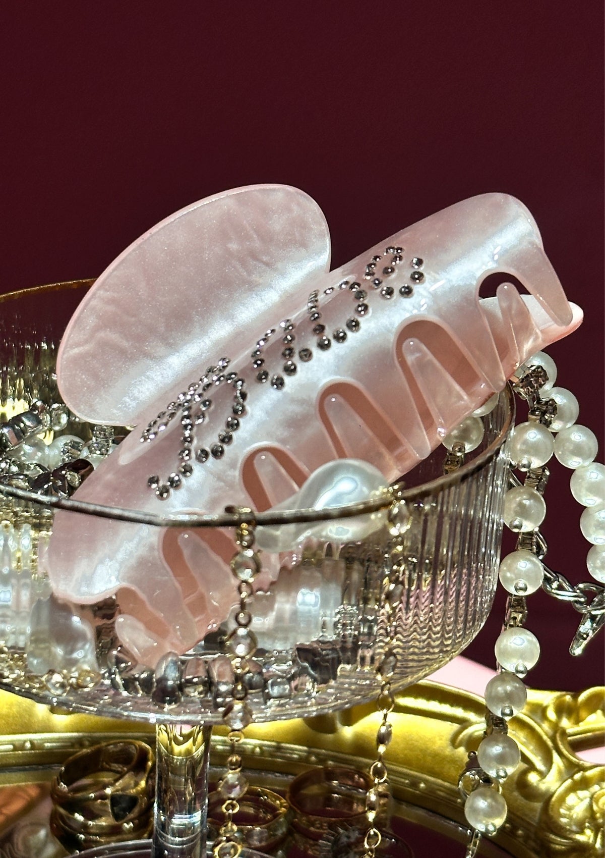 Pink hair clip with decorative elements on a red background