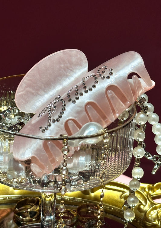 Pink hair clip with decorative elements on a red background