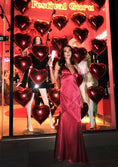 Заредете изображението в програмата за преглед на галерия, Woman in a pink dress standing in front of a decorative window with heart-shaped balloons and 'Festival Guru' sign.
