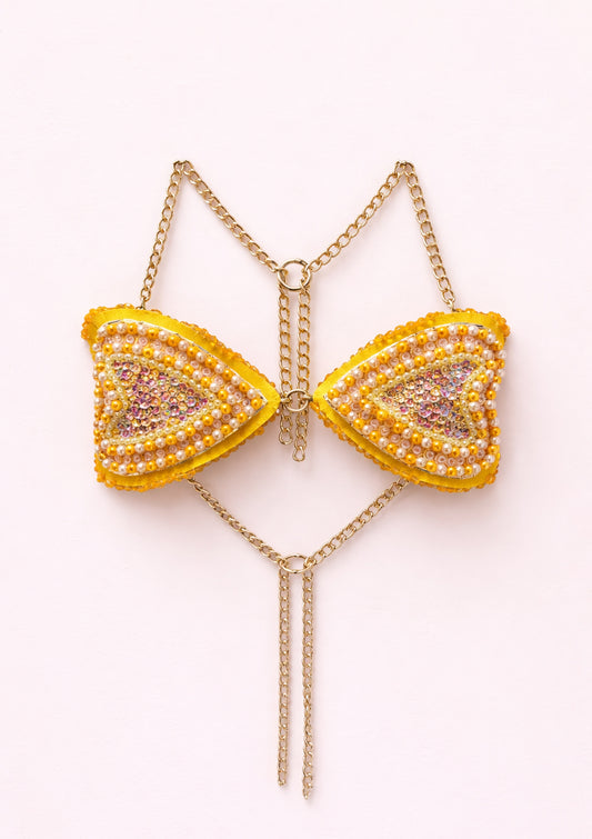 Gold bra with yellow and pink heart-shaped pendants on a white background
