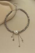 Заредете изображението в програмата за преглед на галерия, Silver beaded necklace with a pearl and charms on a beige surface

