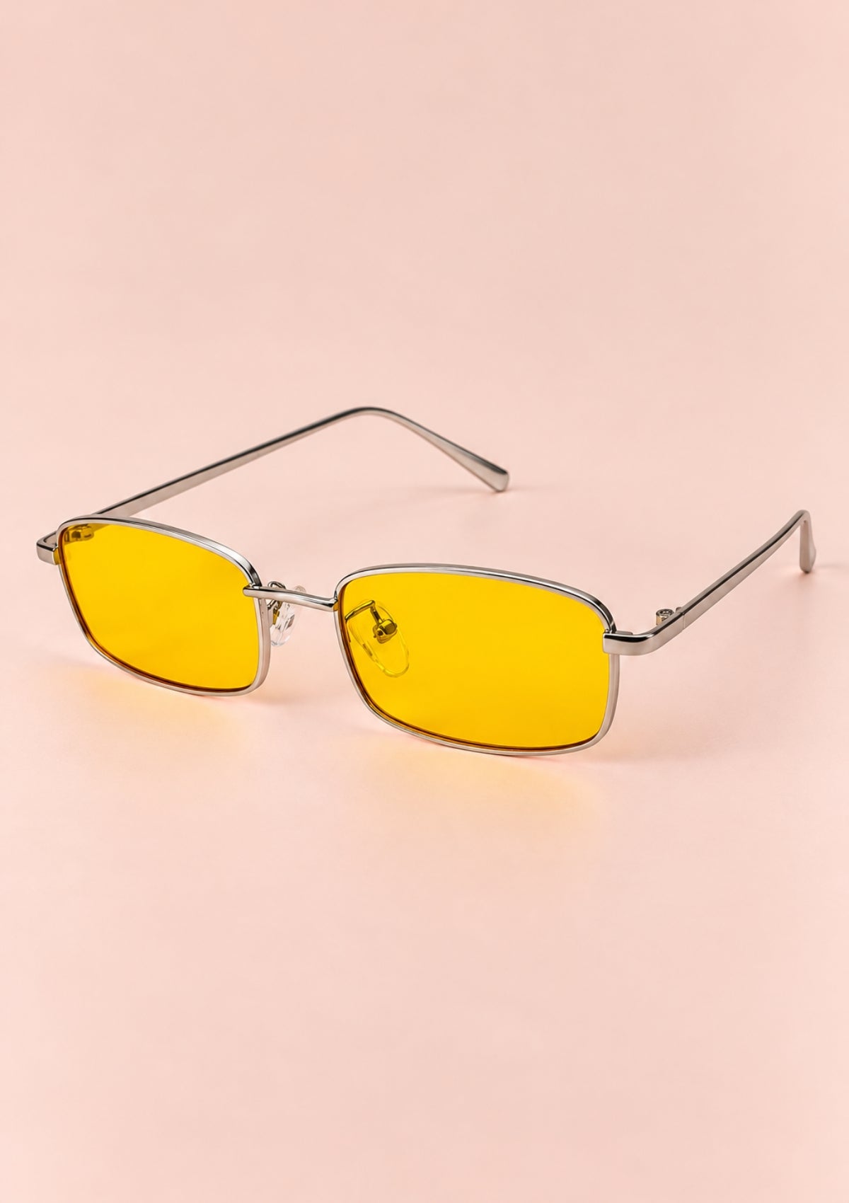 Silver metal sunglasses with yellow lenses and a rectangular frame