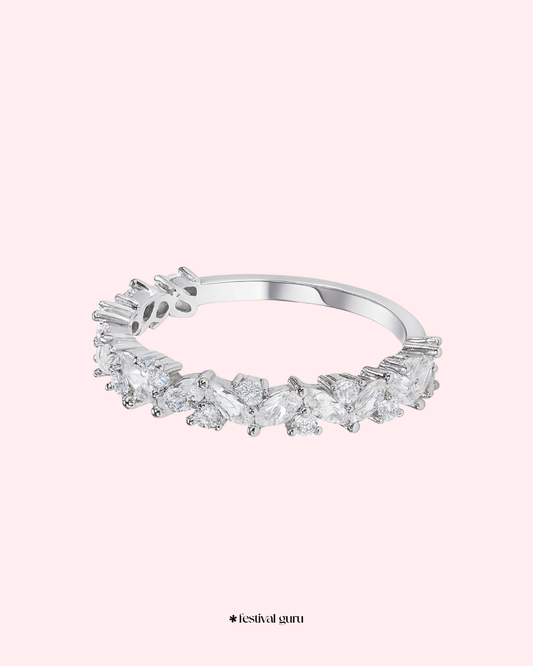 Silver ring with clear gemstones on a light pink background