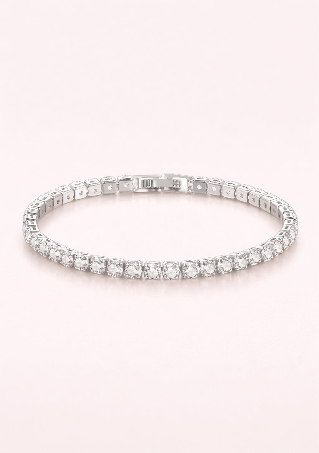 Silver bracelet with clear stones on a light pink background