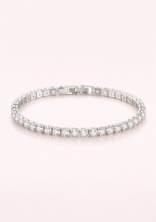 Silver bracelet with clear stones on a light pink background