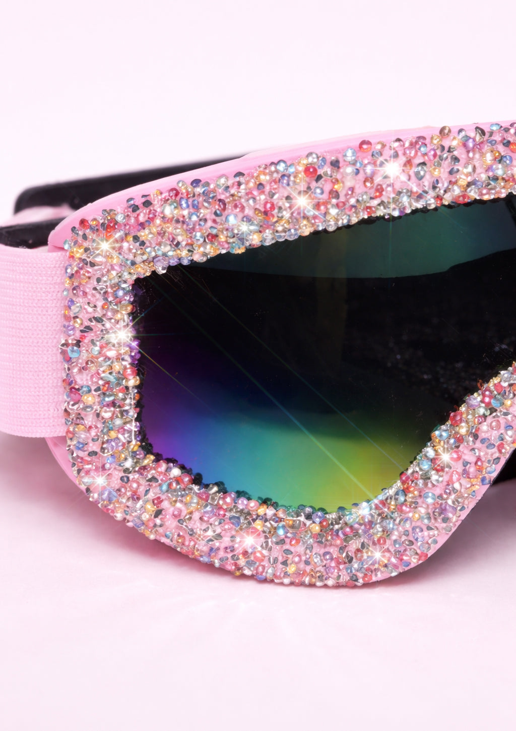 Sunglasses with a pink frame covered in rhinestones on a white background