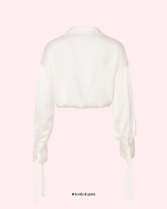 White blouse with sheer sleeves on a light pink background