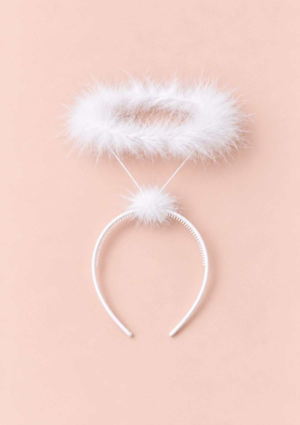 White angel headband with a fluffy white faux-fur halo and pom-pom, displayed on a solid pale peach-pink background.