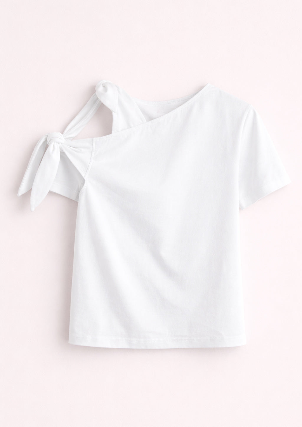 White off-shoulder top on a light pink background