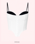 White slip top with black lining on a pink gradient background
