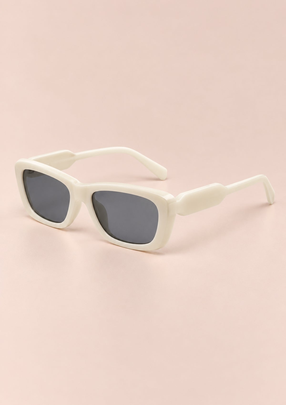White square sunglasses with dark gray lenses, displayed on a soft pink background.