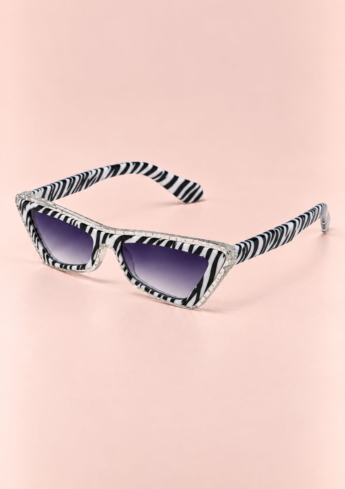 Zebra-print cat-eye sunglasses with gradient purple lenses, displayed on a soft pink background.