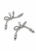 Silver bow-shaped shoe charm on a white background 