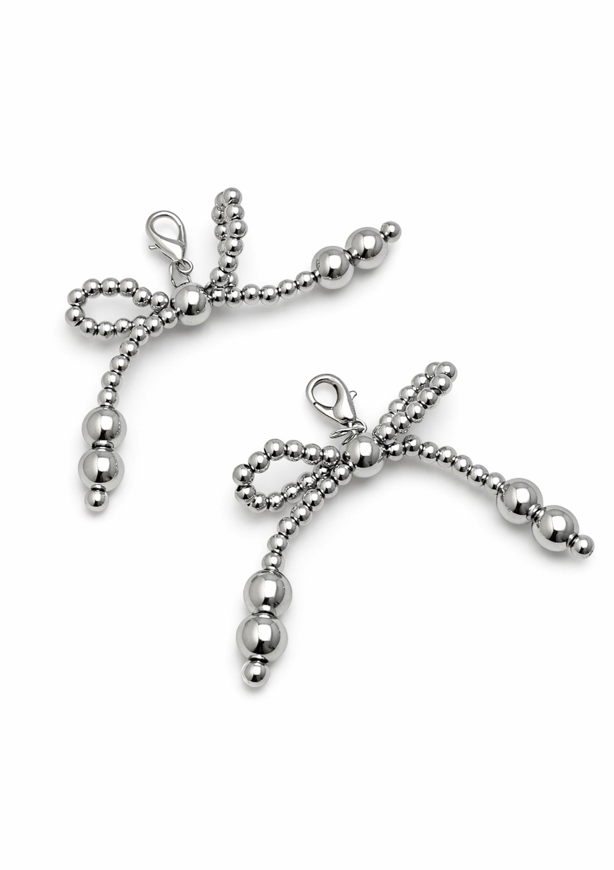 Silver bow-shaped shoe charm on a white background 