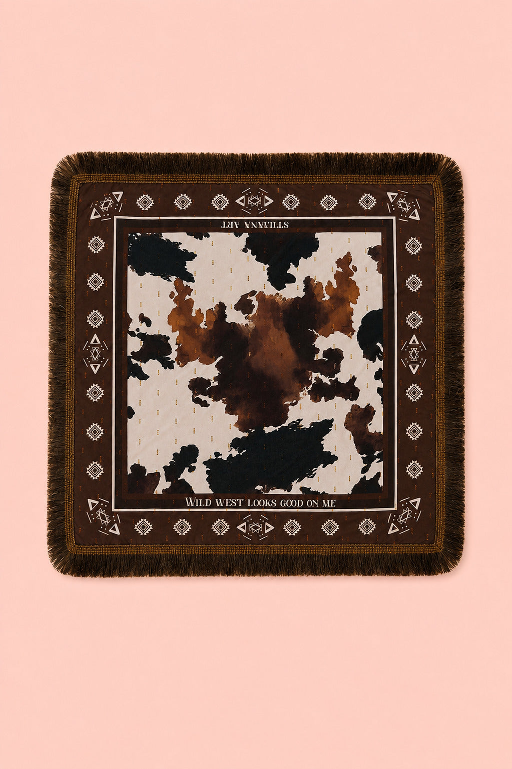 A square fringed scarf with a brown and black cow print center and a dark brown border with geometric patterns, displayed flat against a solid pink background.