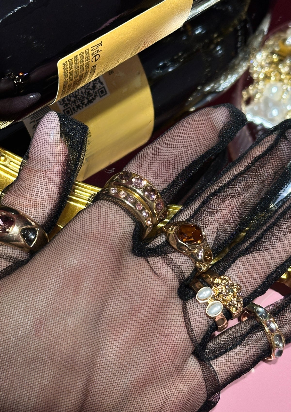 Hand wearing gold rings set with a blurred background