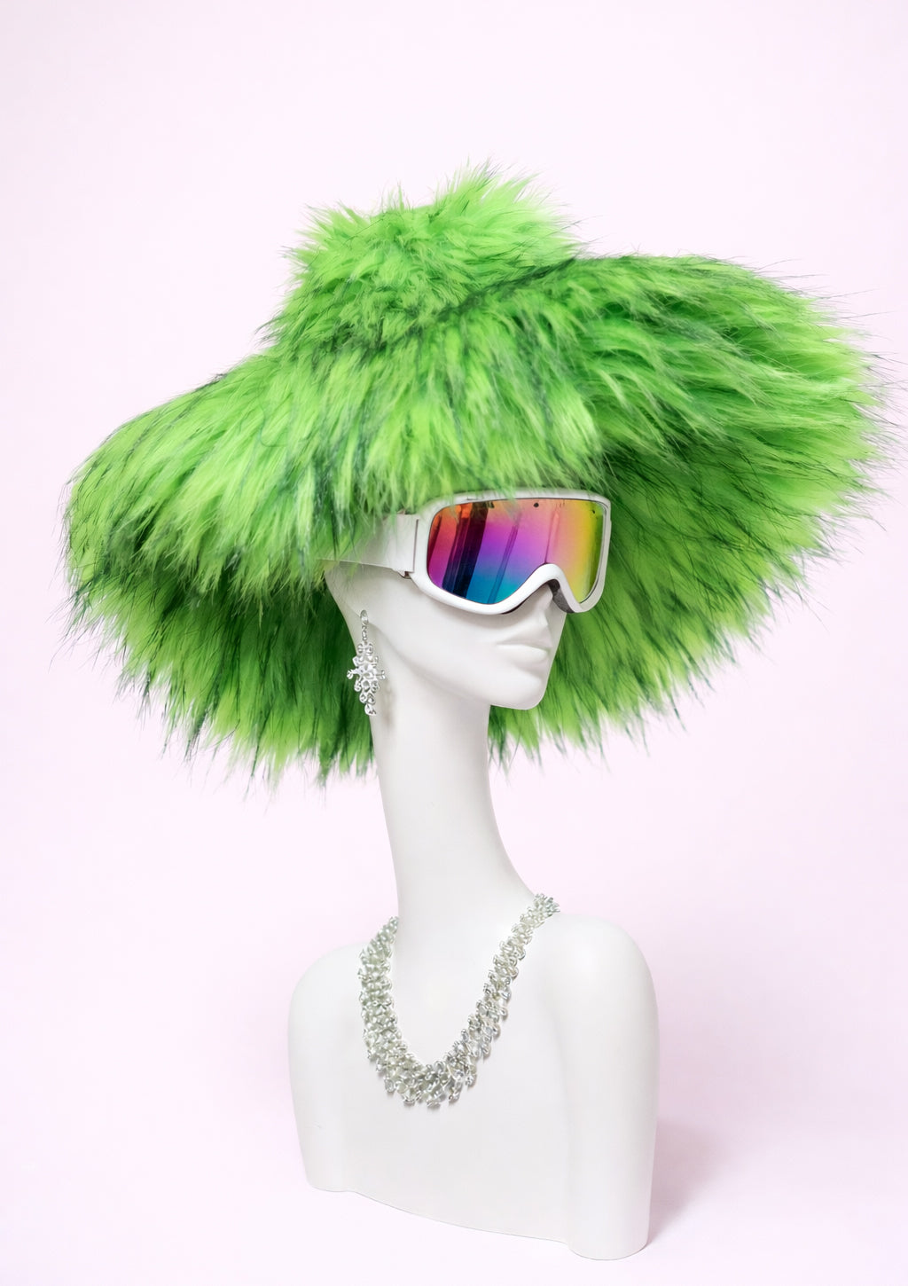 Mannequin head with green furry hat and colorful sunglasses on a white background