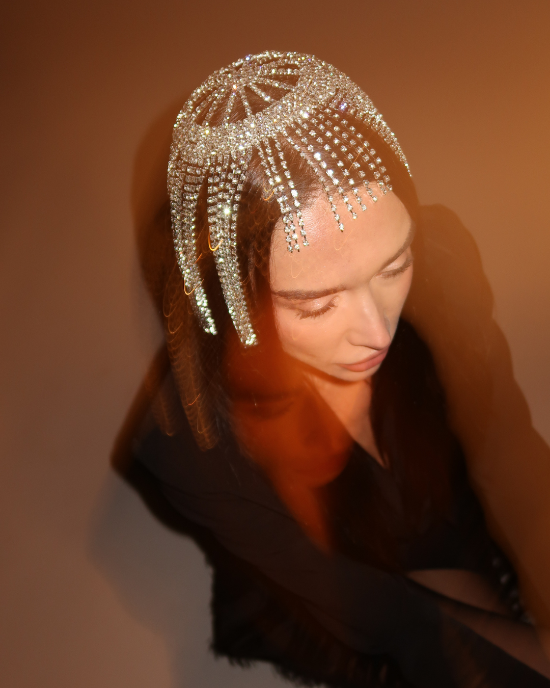 Woman wearing a decorative headpiece with a warm brown background