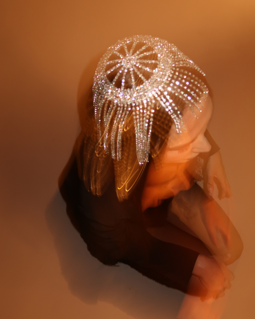 Decorative headpiece with intricate design on a mannequin head against a warm-toned background