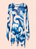 A long-sleeve sheer mesh tunic dress featuring an abstract blue, white, and navy geometric swirl pattern, displayed against a solid pale peach background.