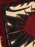 Заредете изображението в програмата за преглед на галерия, Close-up of a woven scarf with a bold sunburst design in red on a black and cream background, plus fringe and the words 'WILD SPIRIT. LOYAL HEART' along the edge.
