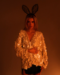 Load image into Gallery viewer, Person wearing a sequined vest and bunny ears against a warm-toned background
