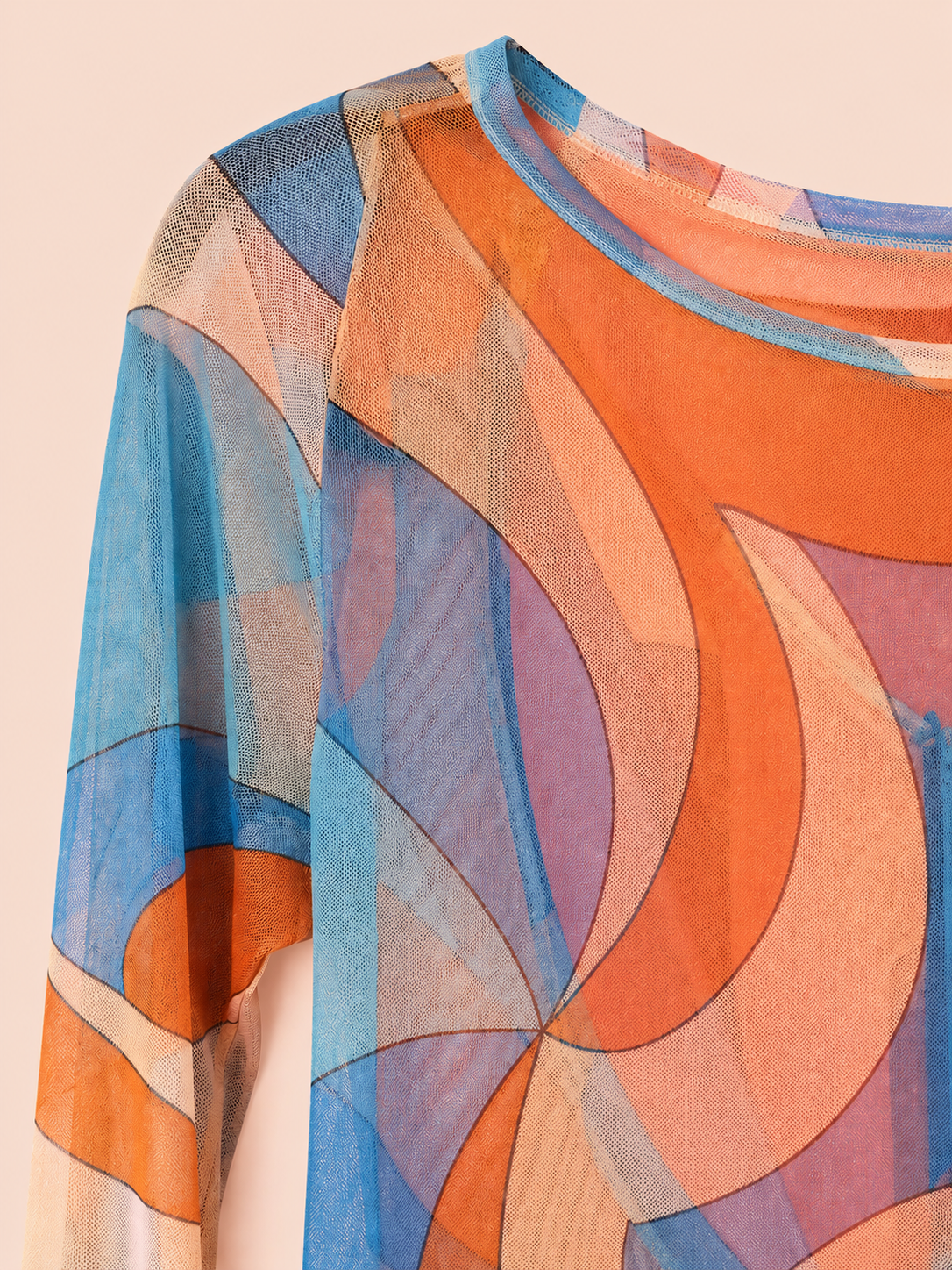 A close-up of a sheer long-sleeve dress with an abstract geometric pattern in orange, blue, purple, and beige, shown against a solid pale pink background.