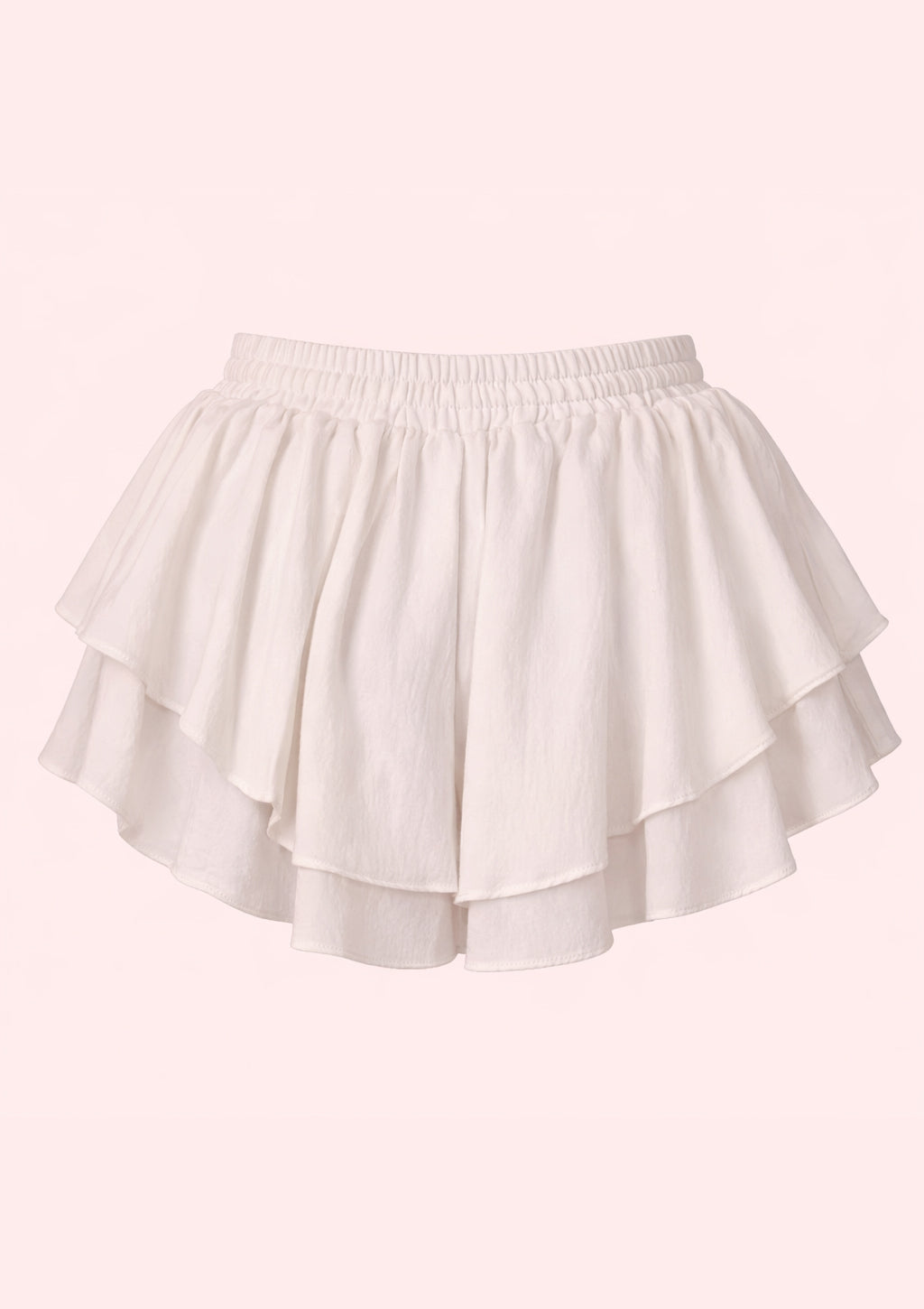 White shorts with ruffled layers on a light pink background