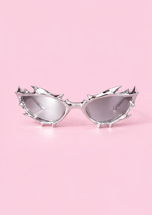 Sunglasses with spike-like designs on a pink background
